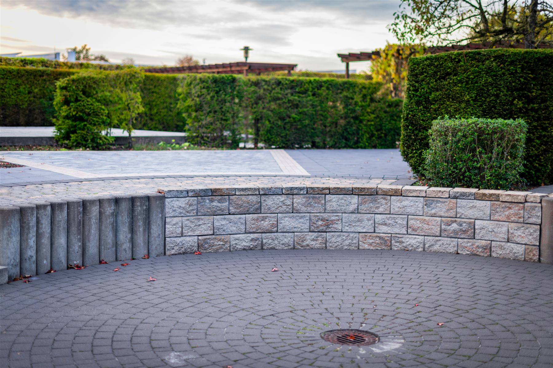 Mur de pierre incurvé autour d'une terrasse pavée